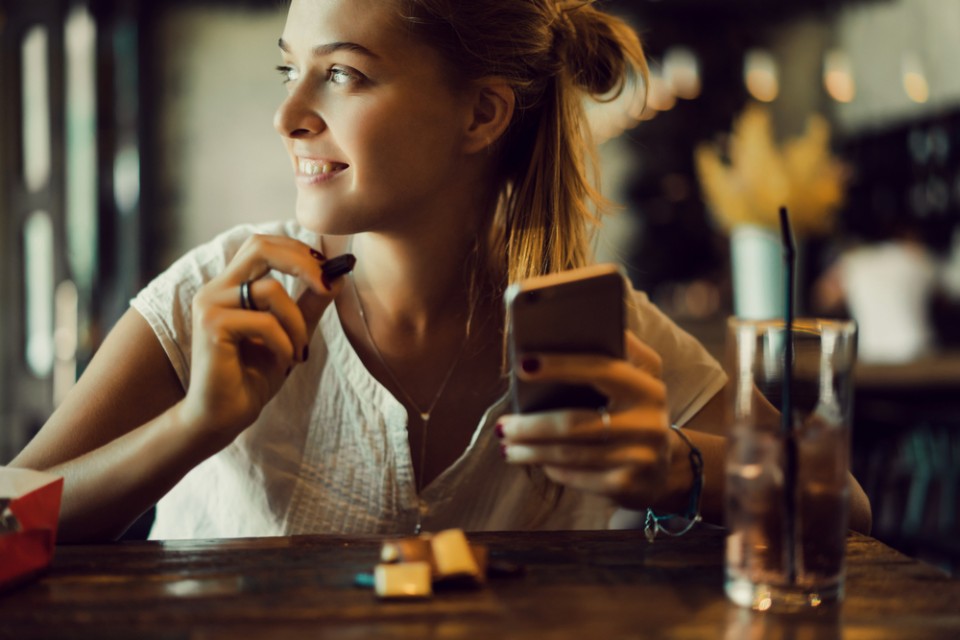 Een vrolijke jonge vrouw met een smartphone vrouw-smartphone