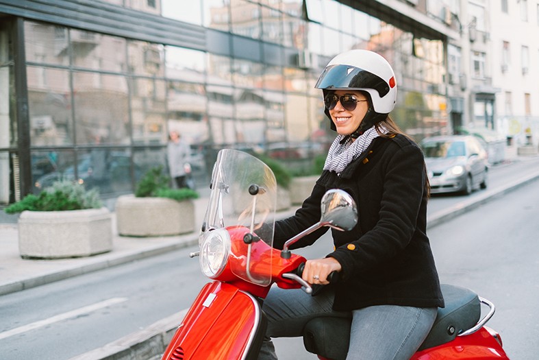 Youg woman riding an electric scooter to rent in Brussels scooty-brussels